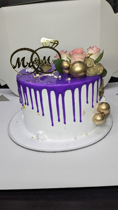 Gravity Cakes purple drip celebration cake with roses and gold accents